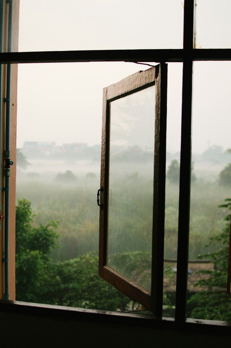 Fenêtre ouverte sur une campagne noyée dans la brume du matin