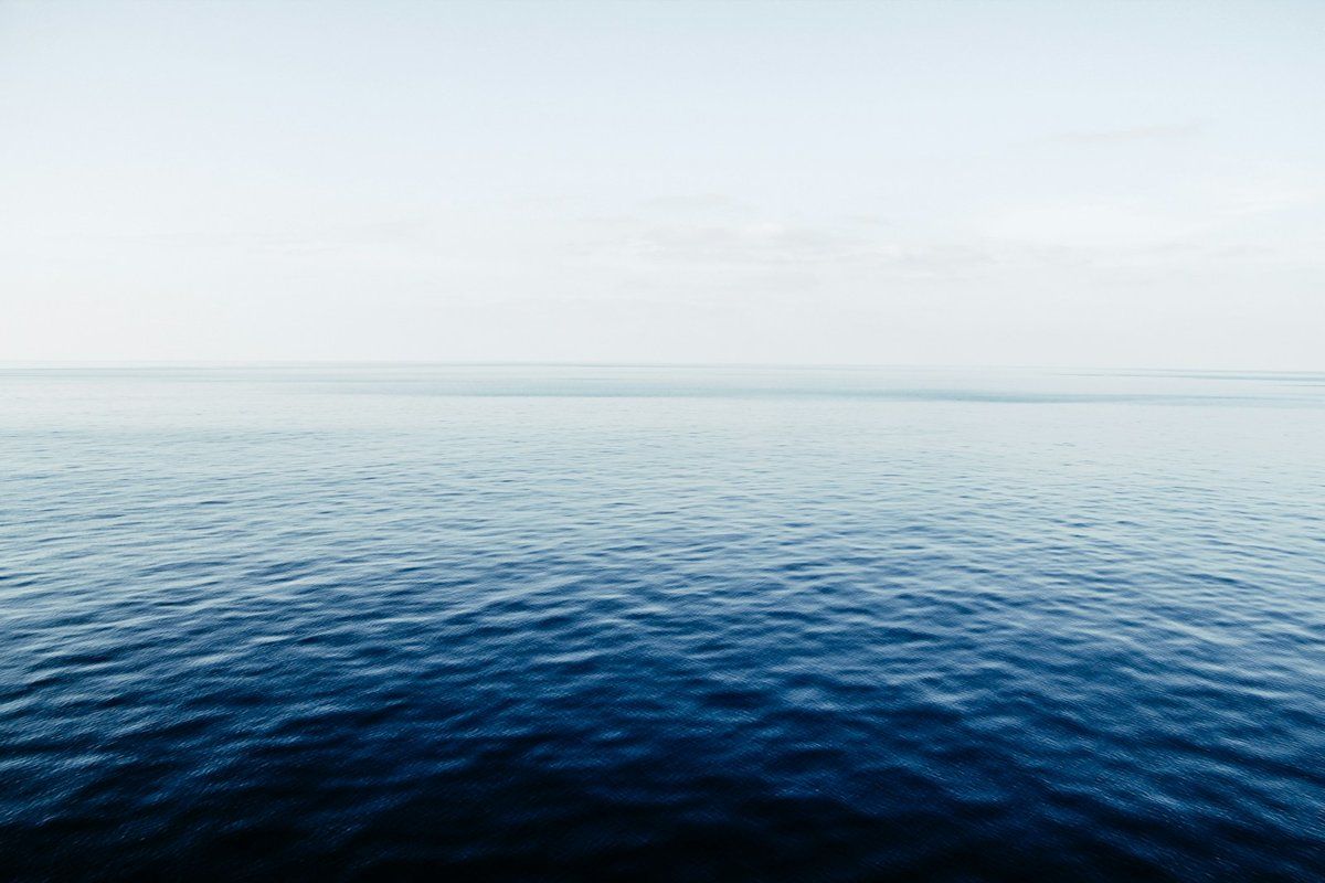 Mer calme sous un horizon pâle, sans vagues ni bateau